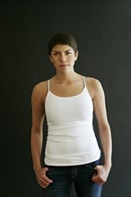 Hispanic woman standing with thumbs in pockets