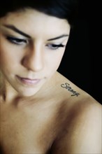 Hispanic woman with strong tattoo on shoulder