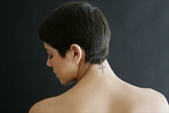 Hispanic woman with crucifix tattoo on neck