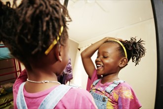 Black girl admiring herself in mirror