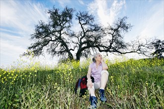 Caucasian woman sitting in tall grass