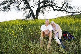 Caucasian couple sitting in tall grass