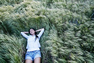 Mixed race woman laying in grass