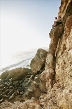 Women climbing rock formation