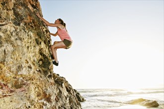 Woman climbing rock formation