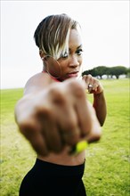 Black woman boxing in field