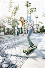 Caucasian woman riding skateboard