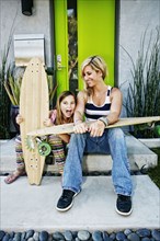 Caucasian mother and daughter with skateboards