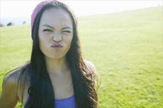 Asian woman making a face outdoors