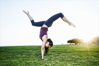 Asian woman practicing yoga outdoors