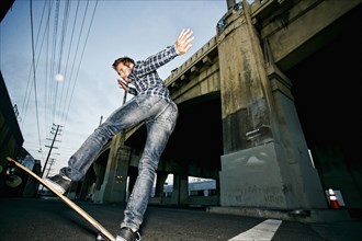 Caucasian man riding skateboard outdoors