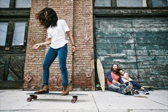 Family riding skateboards on sidewalk
