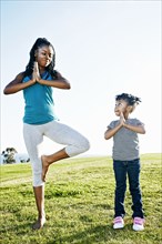 Black mother and daughter practicing yoga