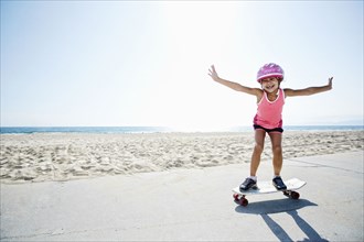 Girl riding skateboard at beach