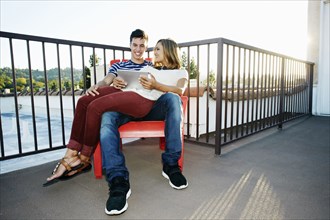 Couple using digital tablet on patio