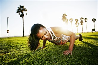 Mixed race athlete doing push-ups in park