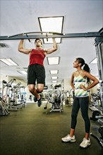 Man working out with trainer in gymnasium