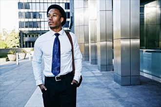 Black businessman walking outside office building