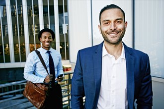Businessmen smiling outside office building
