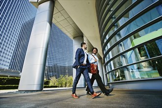 Businessmen walking outside office building