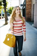Caucasian woman walking on sidewalk
