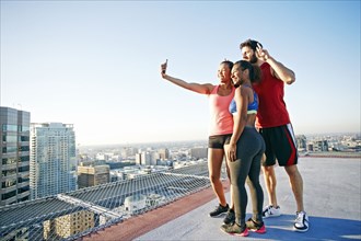 Friends taking selfie on urban rooftop