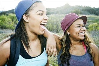 Mixed Race sisters laughing in field