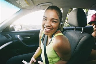 Mixed Race woman laughing in car