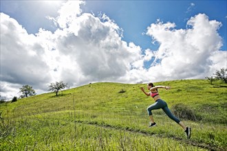 Caucasian woman running on hill
