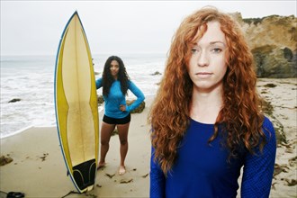 Serious women holding surfboards at beach