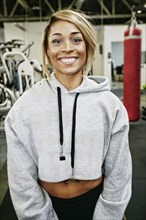 Smiling Mixed Race woman posing in gymnasium