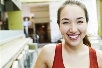 Smiling Mixed Race woman posing in food court