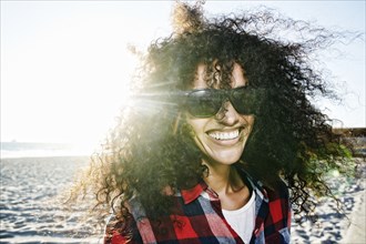 Portrait of smiling Hispanic woman at beach