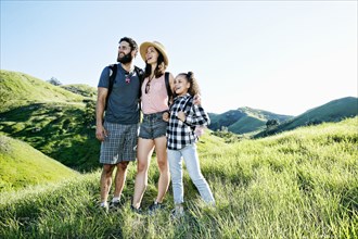 Happy family standing on hill
