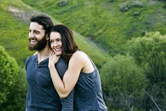 Smiling couple standing on hill