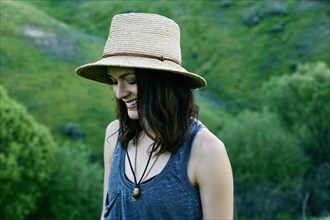 Smiling woman wearing hat on hill