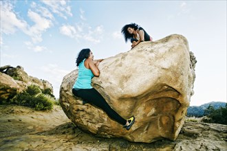 Women climbing on boulder