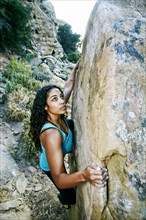 Mixed Race woman rock climbing
