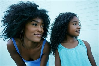 Portrait of Black mother and daughter looking away