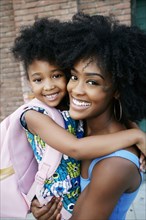 Portrait of Black mother carrying daughter