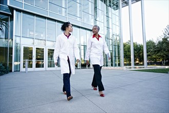 Doctors walking and talking outdoors at hospital