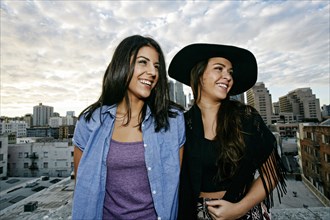 Smiling Hispanic women on urban rooftop