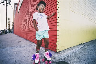 Black girl wearing roller skates on urban sidewalk