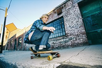Caucasian man skateboarding on urban sidewalk