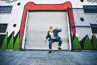 Caucasian man jumping on skateboard