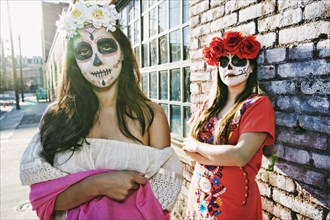 Women on sidewalk wearing skull face paint
