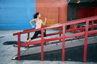 Mixed race woman running up loading dock
