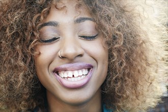 Close up of smiling Black woman with eyes closed