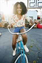 Smiling mixed race woman riding bicycle