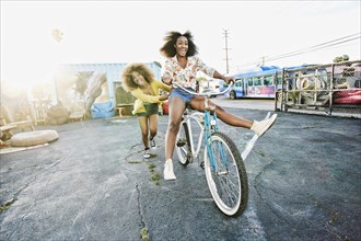 Friend pushing carefree woman on bicycle
